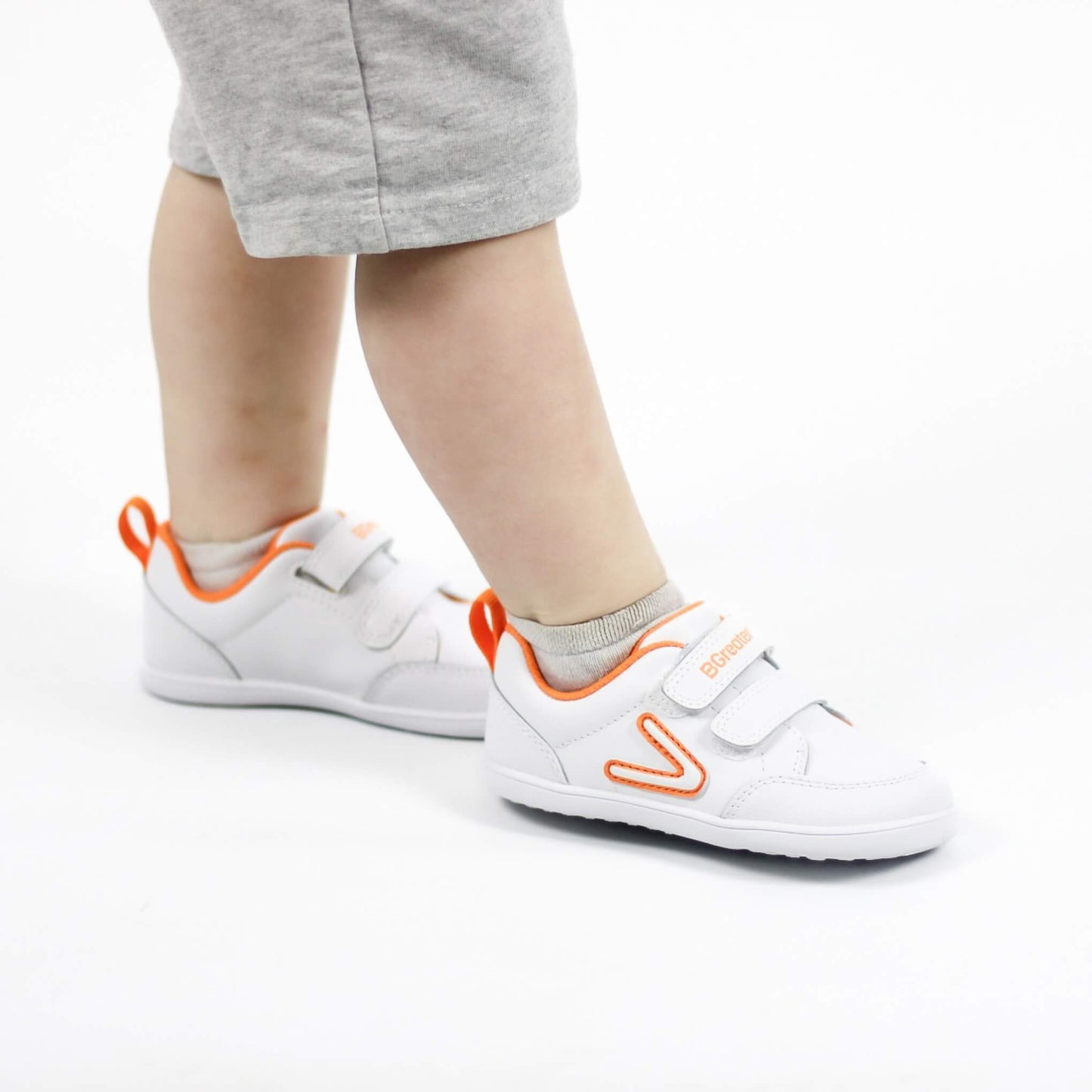 Studio shot of boy wearing white barefoot trainers