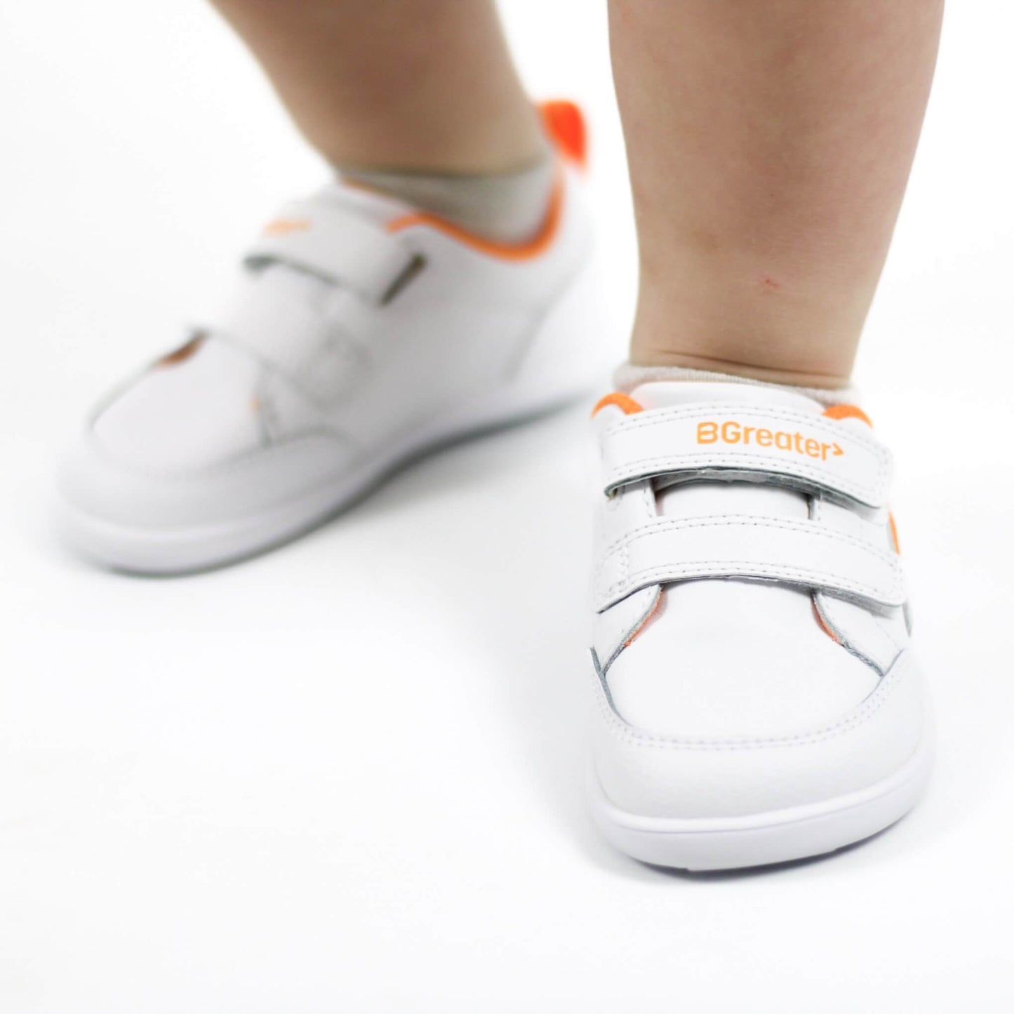 Close up studio shot of feet of boy wearing white barefoot trainers