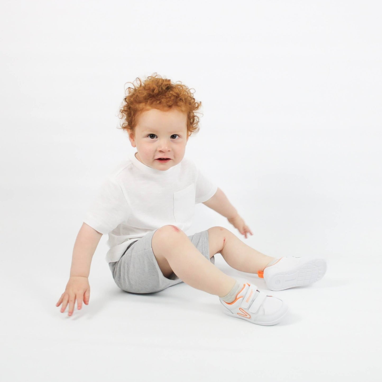 Studio shot of boy wearing white barefoot trainers