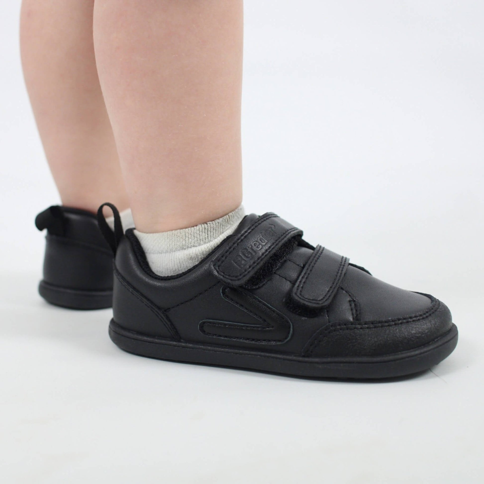 Studio shot of toddler wearing black barefoot trainers close up