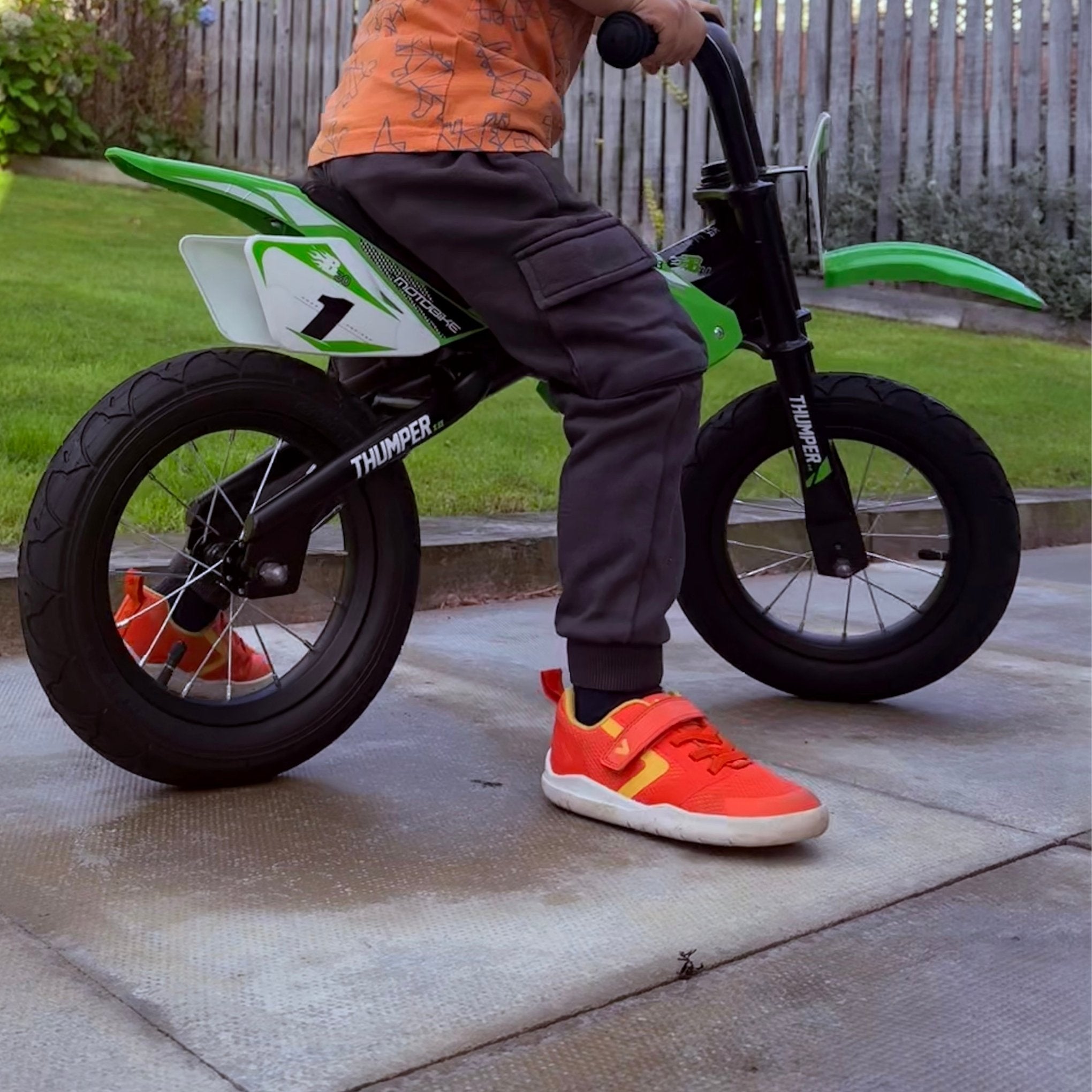 Boy wearing orange barefoot trainers on bike