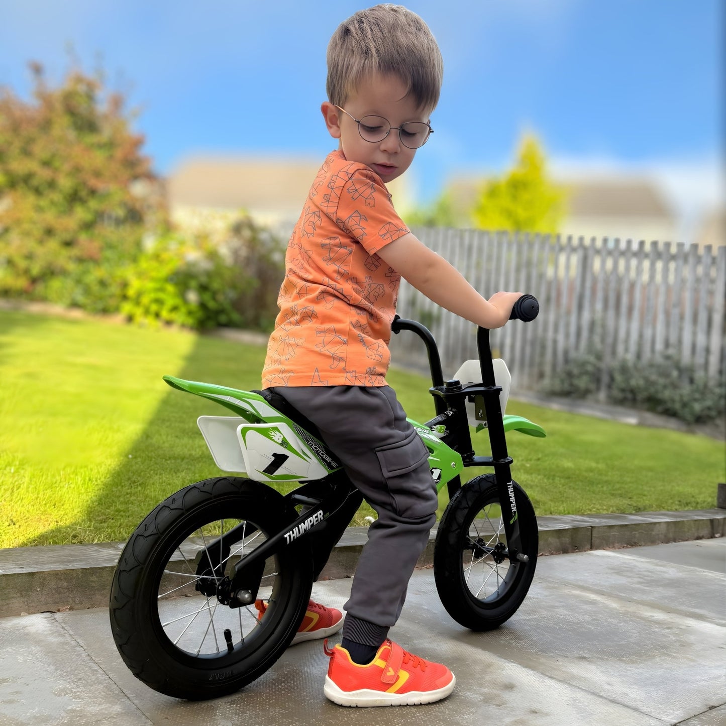 Boy wearing orange barefoot trainers on bike