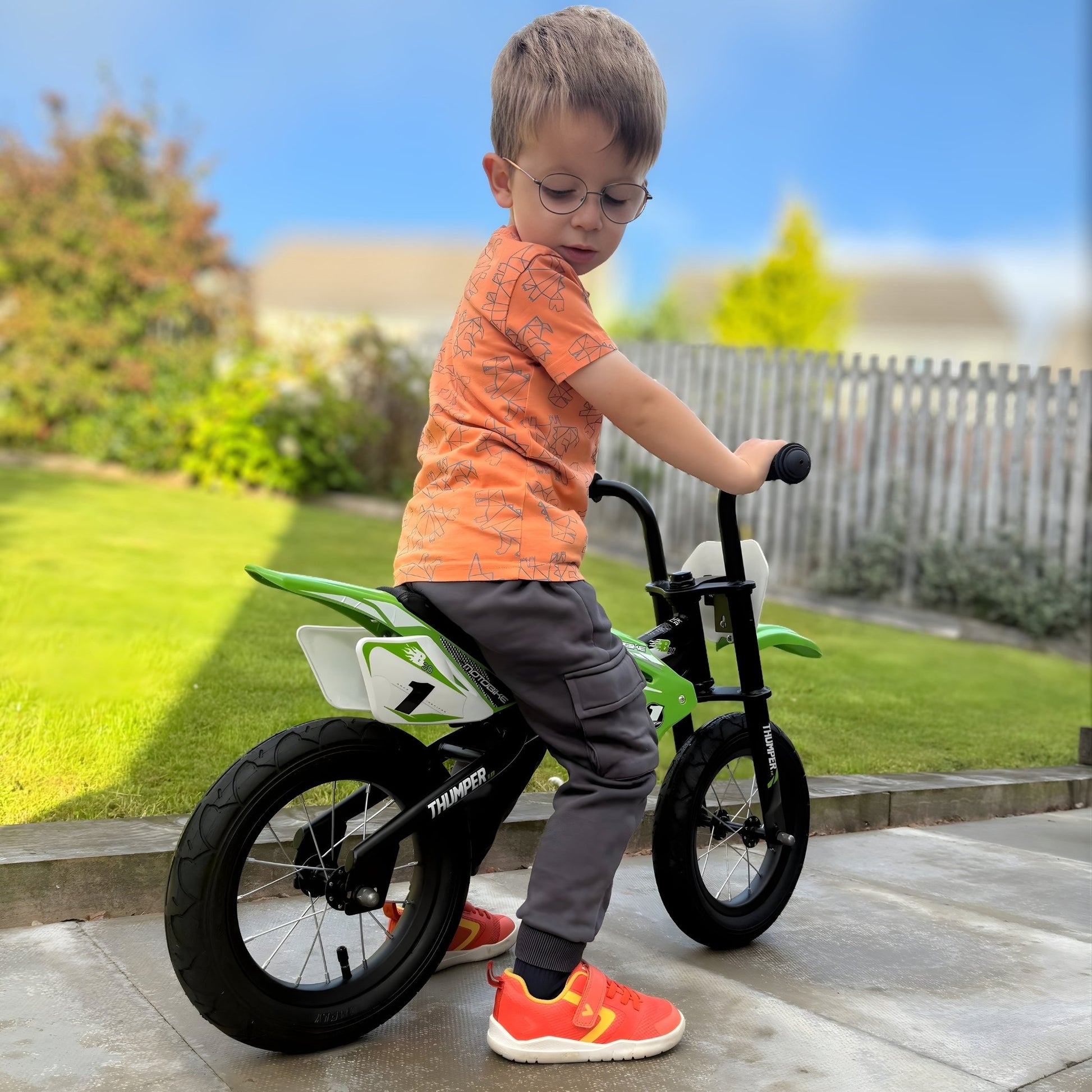 Boy wearing orange barefoot trainers on bike