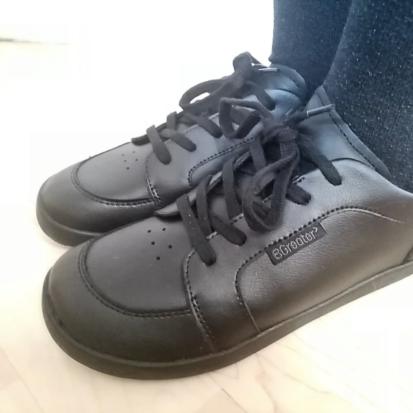 Close up of boy wearing back barefoot school shoes