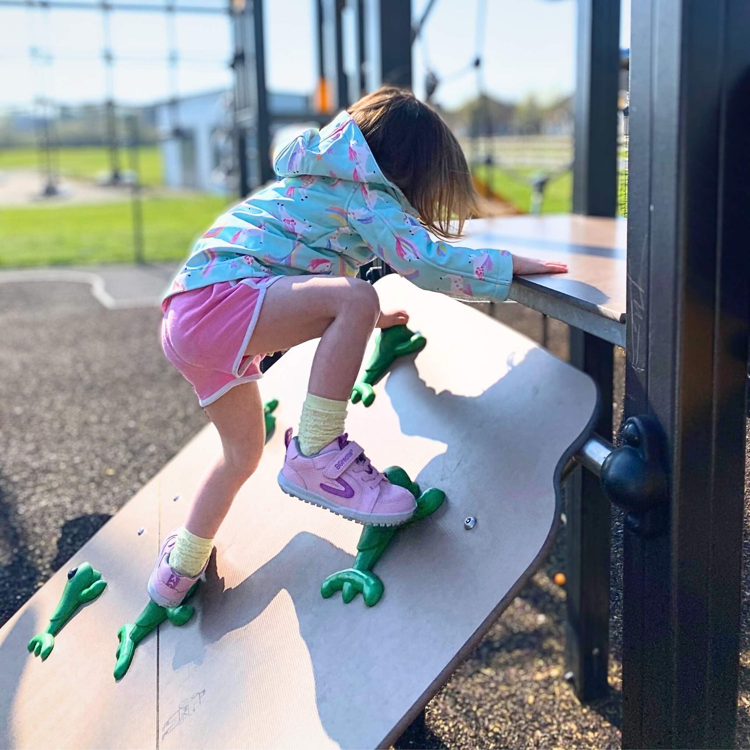 Girl climbing in playground wearing pink barefoot trainers